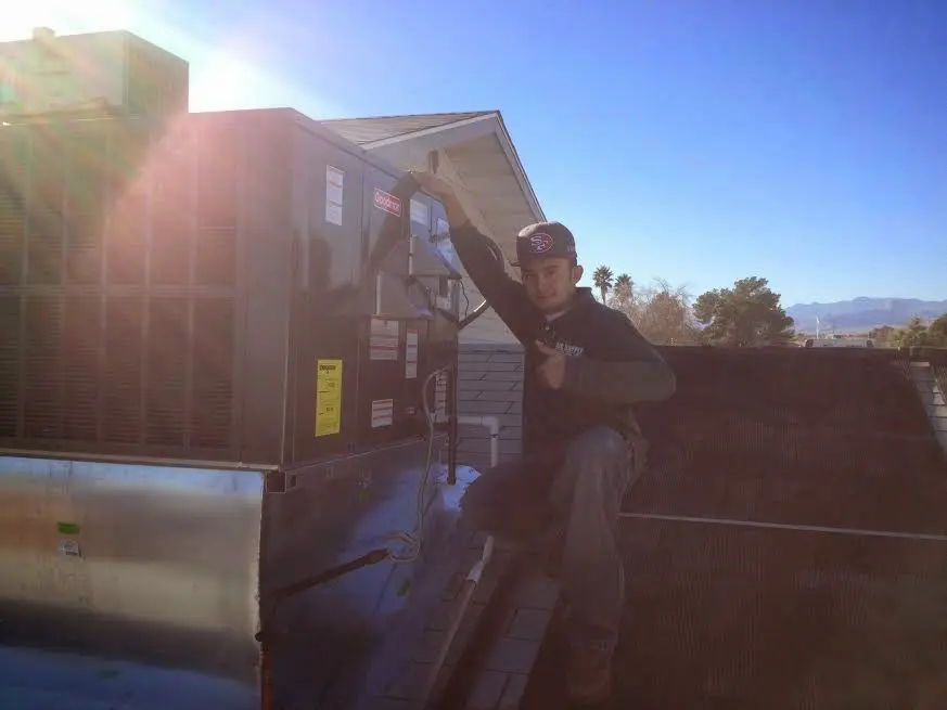 HVAC technician performing AC Tune-Up on a rooftop unit in Decatur